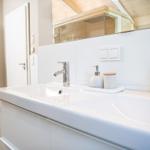 Badezimmer mit Doppelwaschbecken, Spiegel und Heizkörper