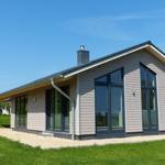 Moderne Villa mit großzügigen Fenstern und Terrasse im Grünen.