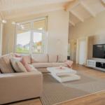 Wohnzimmer mit Sofa, Couchtisch und Fernseher an der Wand.