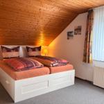 Schlafzimmer mit Doppelbett, Holzdecke und Fenster mit Vorhängen.