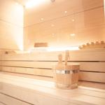 Sauna mit Holzbank und Eimer mit Besen.