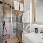 Dusche mit Glaswand, Waschbecken und Handtuchhalter