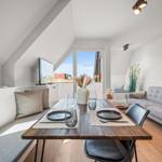 Essbereich mit Tisch und Stühlen, Sofa und Fenster mit Blick.