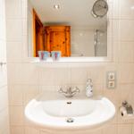 Bad mit Waschbecken, Spiegel und Dusche