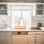 Küche mit Fenster, Spüle, Herd und Schränken