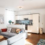 Wohn- und Küchenbereich mit Sofa, Küchenzeile und Holzboden.