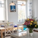 Ein Essbereich mit Tisch, Stühlen und Blumenarrangement auf der Arbeitsplatte.