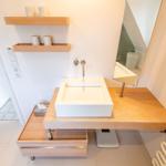 Sink on wooden vanity with mirror and shelf