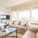 Living room with sofa, TV, and large window with view outside.