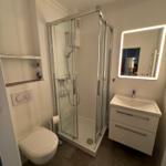 Badezimmer mit Dusche, Waschbecken und Toilette
