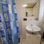 Badezimmer mit Dusche, Waschbecken und Spiegel