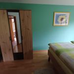 Schlafzimmer mit Bett, Kleiderschrank und Wandbild.