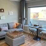 Wohnzimmer mit Sofa, Esstisch und Balkonansicht.