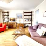 Living room with sofa, armchair, coffee table, and TV.