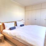 Bedroom with double bed, wooden frame, nightstand, and wardrobe.