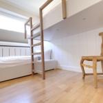 Bedroom with double bed, wooden chair, and window