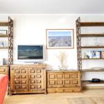 Living room with wooden furniture, TV, and bookshelves.
