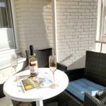 Terrace with table, two chairs, and a bottle of Sylt sparkling wine.