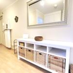 Entryway with white cabinets and baskets. Mirror on the wall.