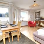 Dining area with table and chairs, living area with sofa and armchair.