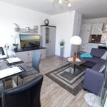 Wohnung mit Essbereich, Wohnzimmer und Küche. Sofa, Esstisch und TV sichtbar.