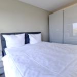 Schlafzimmer mit Doppelbett, Nachttisch und Kleiderschrank.