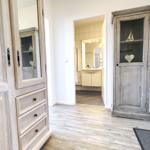 Flur mit Schrank und Blick in die Badewanne.