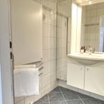 Badezimmer mit Waschbecken, Spiegel und Handtuchhalter.