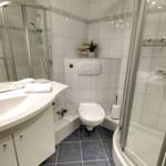 Badezimmer mit Dusche, Waschbecken und Toilette.