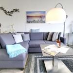 Ein Wohnzimmer mit grauem Sofa, Tisch und Teppich.