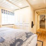 Schlafzimmer mit Bett, Fenster und Tür zum Flur