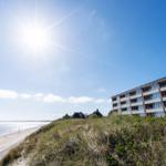 Beach house with sea view under blue sky.