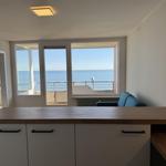 Apartment with kitchen island and sea view from balcony