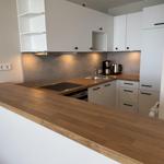 Modern kitchen with wooden countertop and white cabinets.
