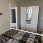 Bedroom with bed frame, wardrobe, and door to bathroom.