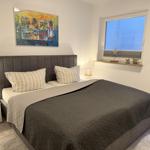 Schlafzimmer mit Bett, Nachttischen und Fenster