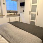 Schlafzimmer mit Bett, Kleiderschrank und Fenster