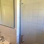 Bad mit Dusche, Spiegel und Waschbecken