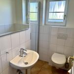 Badezimmer mit Waschbecken, Toilette und Dusche.