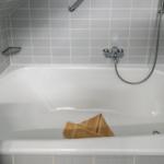 Badewanne mit Duschbrause und Handtuch