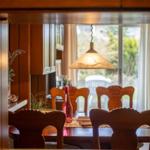 Esszimmer mit Holztisch, Stühlen und Fensterblick auf Garten