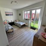 Zwei Betten, Fenster mit Blick auf Garten, Holzboden und Kleiderschrank