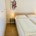 Schlafzimmer mit Bett, Nachttisch und Wandbild