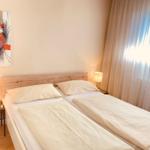 Ein Schlafzimmer mit Doppelbett, zwei Nachttischen und einem Wandbild.