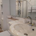Badezimmer mit Waschbecken, Spiegel und Dusche