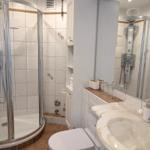 Badezimmer mit Dusche, Waschbecken und Toilette.