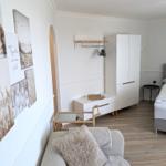 Schlafzimmer mit Bett, Kleiderschrank und Wandbildern