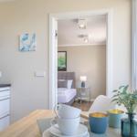 Küche mit Essbereich und Blick in Schlafzimmer. Fenster mit Blick auf Dächer.
