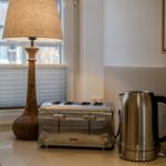 Küchenarbeitsfläche mit Toaster, Kaffeekocher und Stehlampe vor Fenster
