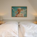 Zwei Betten mit weißen Bettwäsche, Wandbild und zwei Nachttische mit Lampen.